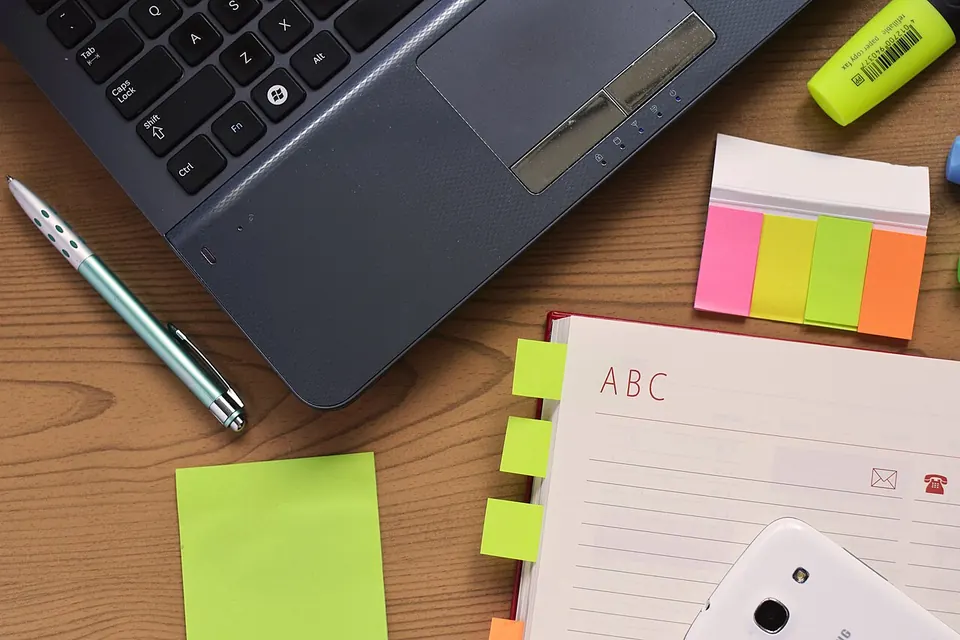 Carnet, stylo et ordinateur sur une table de travail